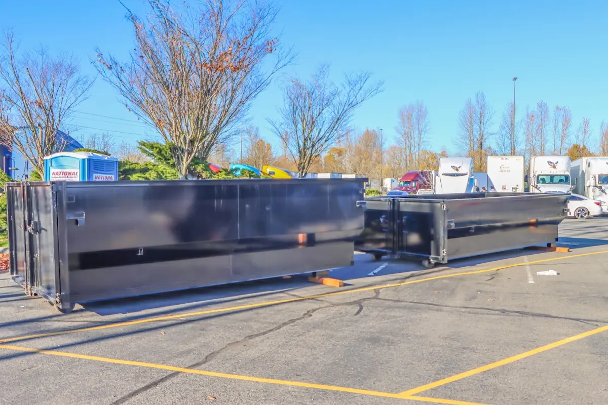 Professional dumpster rental service with roll-off container on residential driveway in Evans